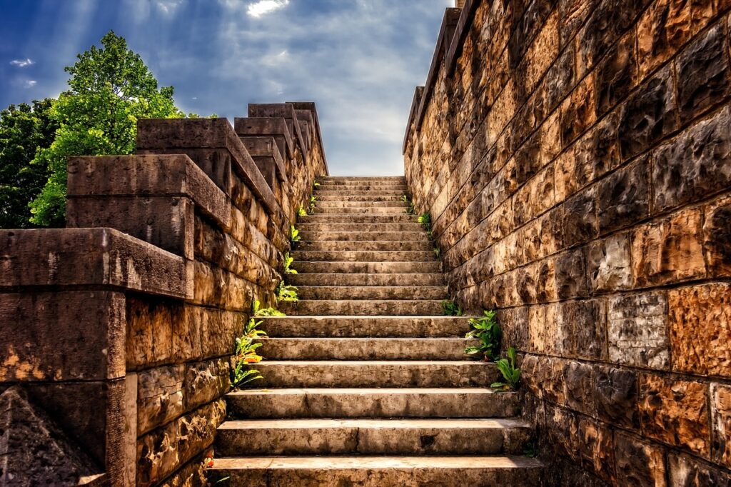 A set of stone steps, strong and solid, climbing upwards to a blue sky