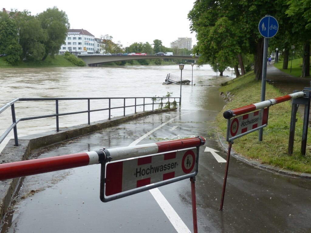 Barriers blocking the road, which runs beside a river which has burst its banks. What happens when it all goes horribly wrong?