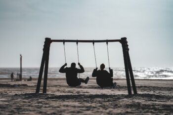 Two people, playing on swings on a beach, having fun without a care in the world. That's what happens when you have a plan.