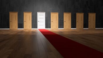 7 doors, only one is spotlit and is white. Which door do you choose? The white one with the red carpet, or maybe a less conventional choice?