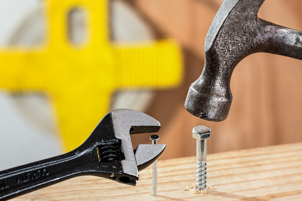 A picture of using tools incorrectly - a hammer to tighten a bolt and a spanner to adjust a nail. It's all about using the right tools at the right time.