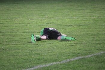 A footballer laying in the ground in despair. It's OK to be disappointed. It's what you do next that counts.