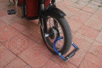 A motorbike, its front wheel locked, unable to move forward.