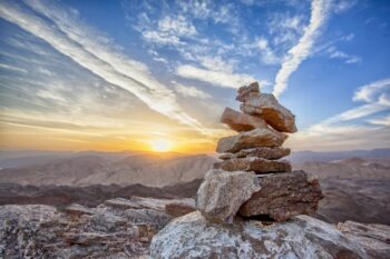 Rocks balanced perfectly on each other, blue skies and a rising sun. It's a new day.