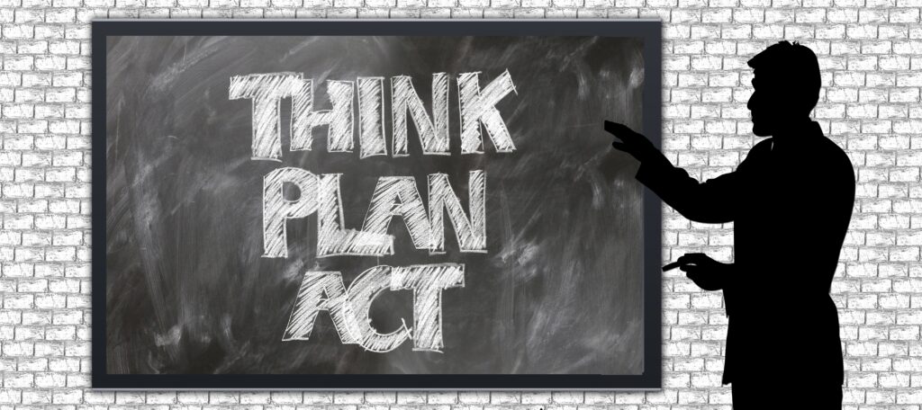 Silhouette of a person pointing at a chalkboard that reads THINK PLAN ACT in chalk.