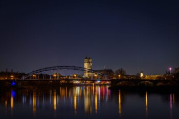 A night time scene of a small town, lights reflecting in a river