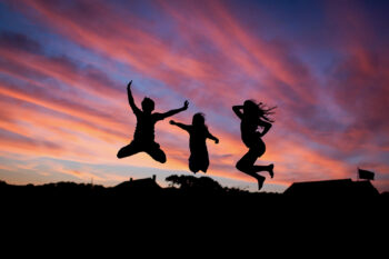 Three people jumping in the air, celebrating their success