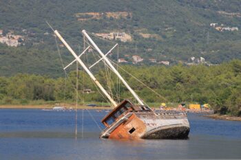 A shipwreck, an aging ship listing in the sea, far from its prime